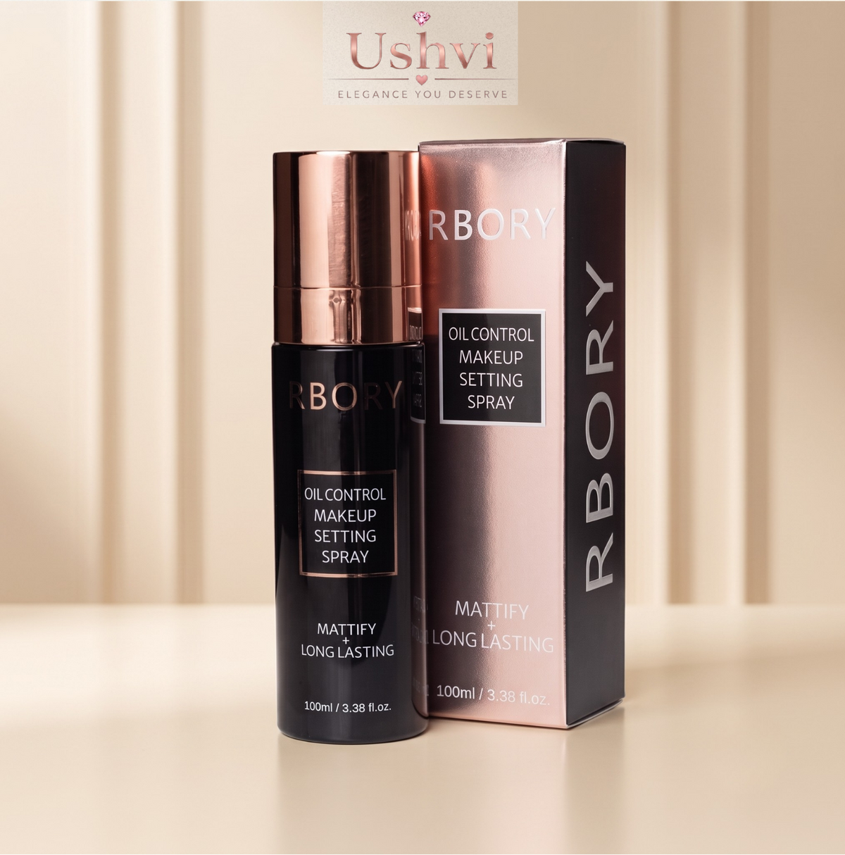 A bottle of RBORY Oil Control Makeup Setting Spray next to its packaging box, both in black with rose gold accents, set against a warm beige background with a soft shadow.
