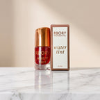 RBORY Professional water tint bottle with a metallic gold cap next to its retail box, displayed on a white surface over artificial green grass against a white backdrop.Ushvi.pk