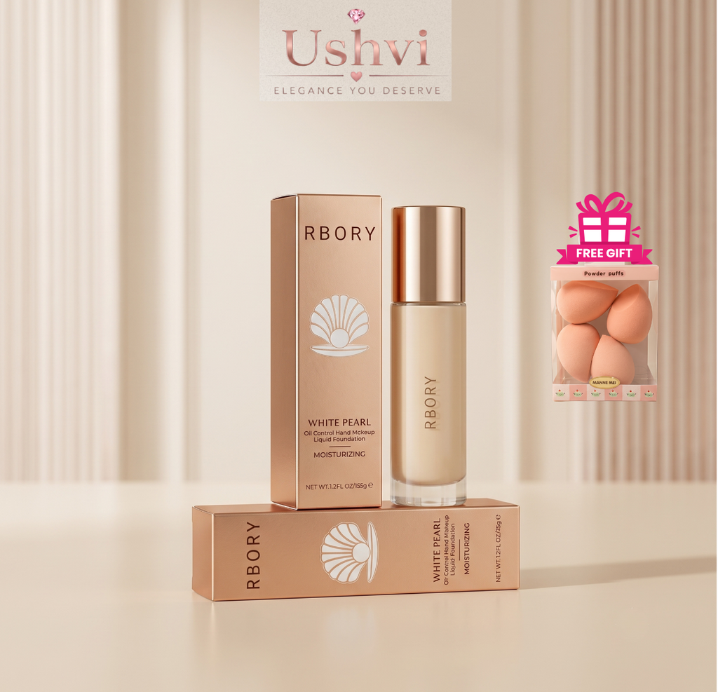 A bottle of RBORY Beauty & Glow liquid foundation with a metallic rose gold cap, displayed next to its matching rose gold box and a smaller box on a beige surface. The background features a soft beige curtain design with the Ushvi Cleanse & Revive logo at the top.